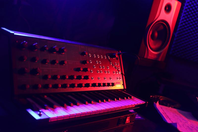 A synthesizer and studio speaker in red light